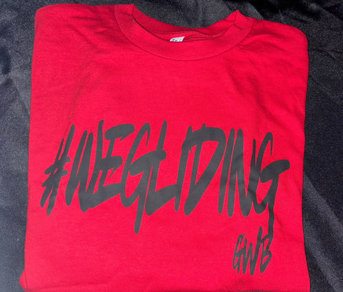 Folded red t-shirt with black text on a dark textured background